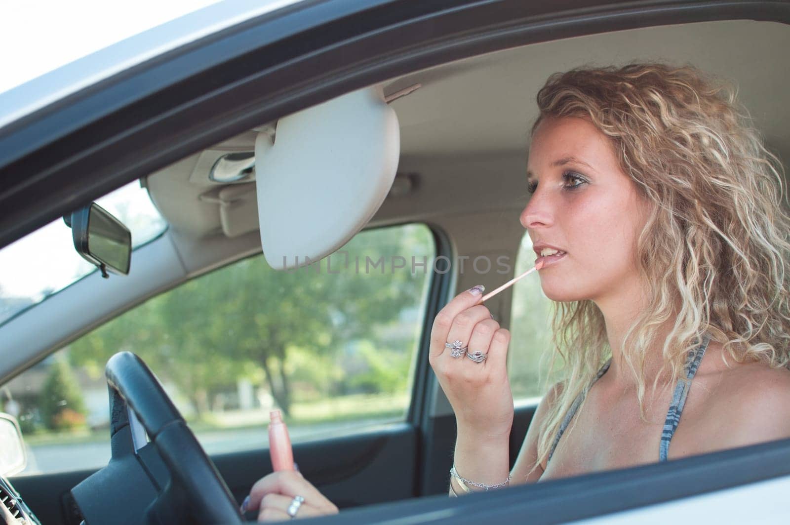 Young woman doing make up in car