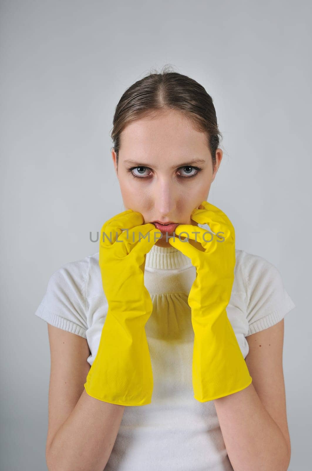 Young woman wearing yellow work gloves with thoughtful expression