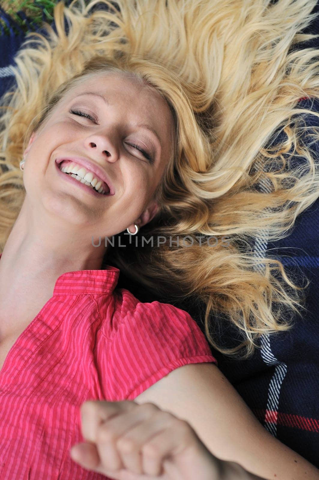 Young blond woman lying on rug and laughing  very much