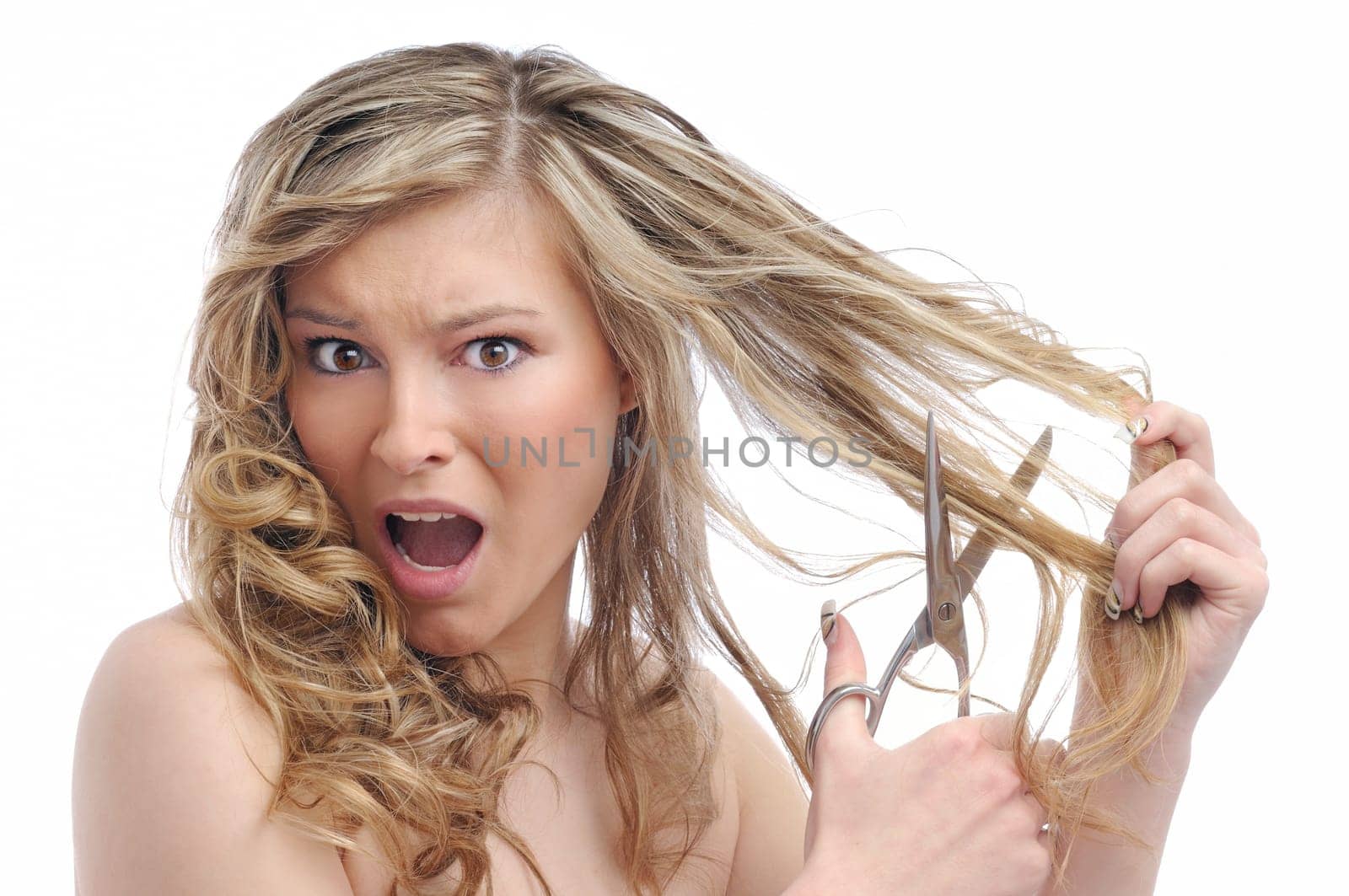 Young beautiful woman cutting her hair with scissors - very unhappy expression, isolated on white background