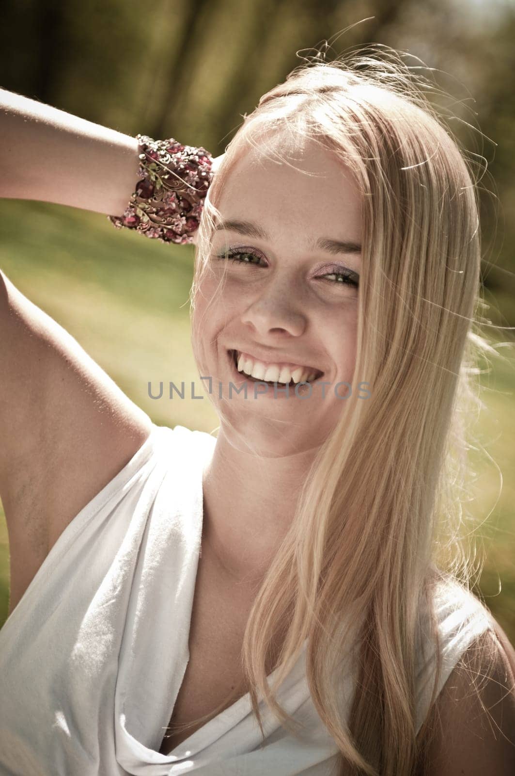 Warm tone outside portrait of young smiling woman - hand behind head