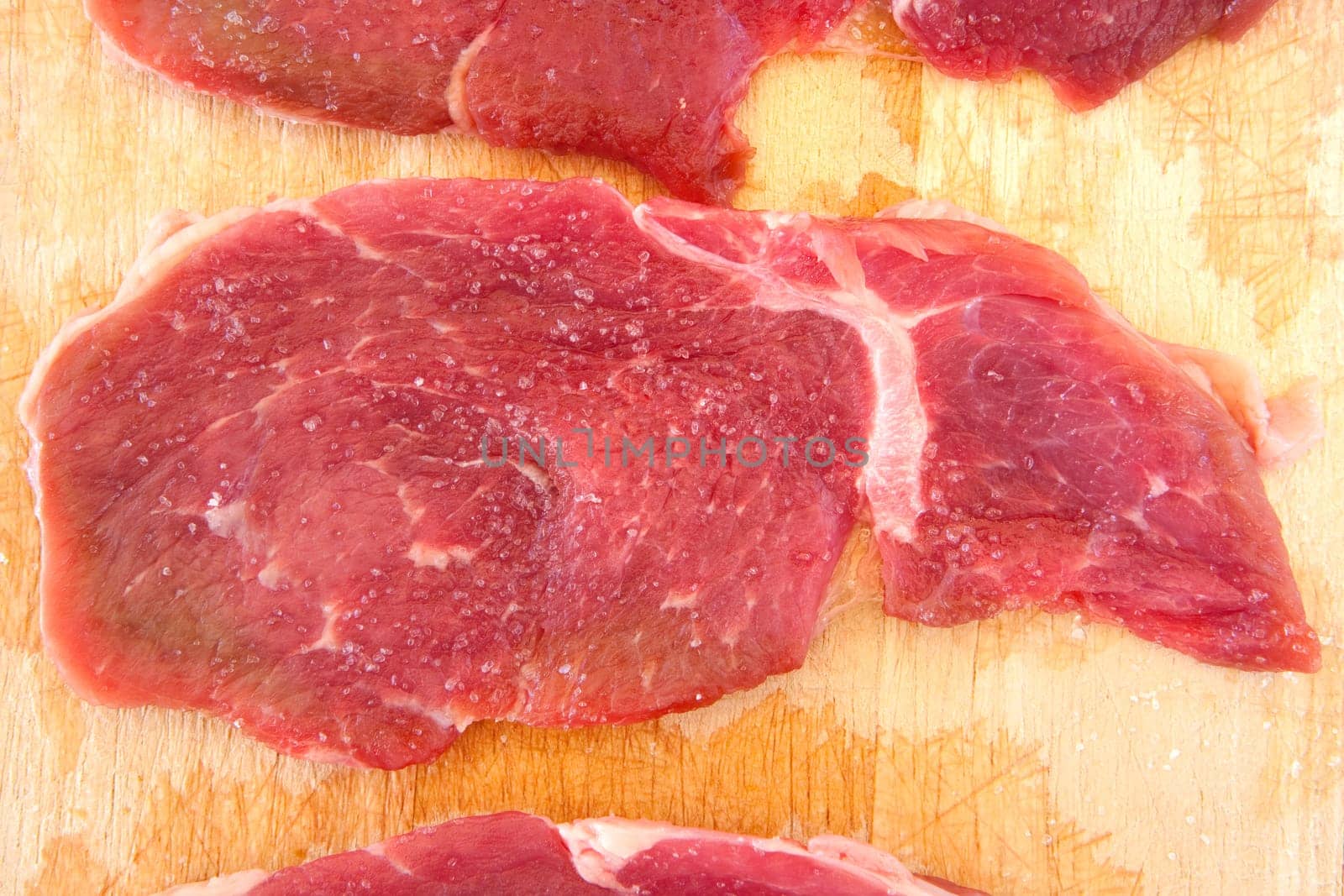 Steaks raw salted pork on cutting board