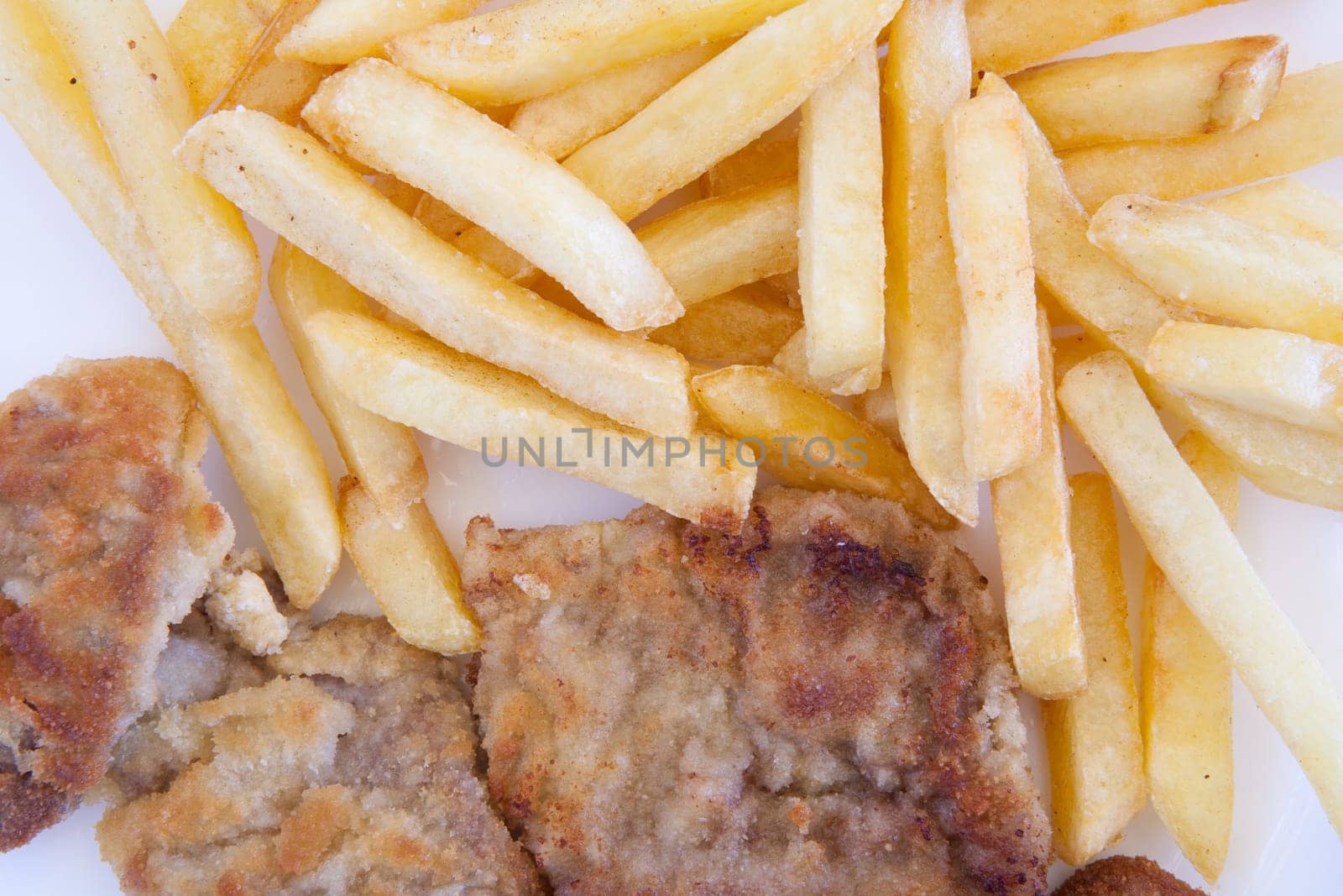 Chips and cooked pork fillets. Example of fast food