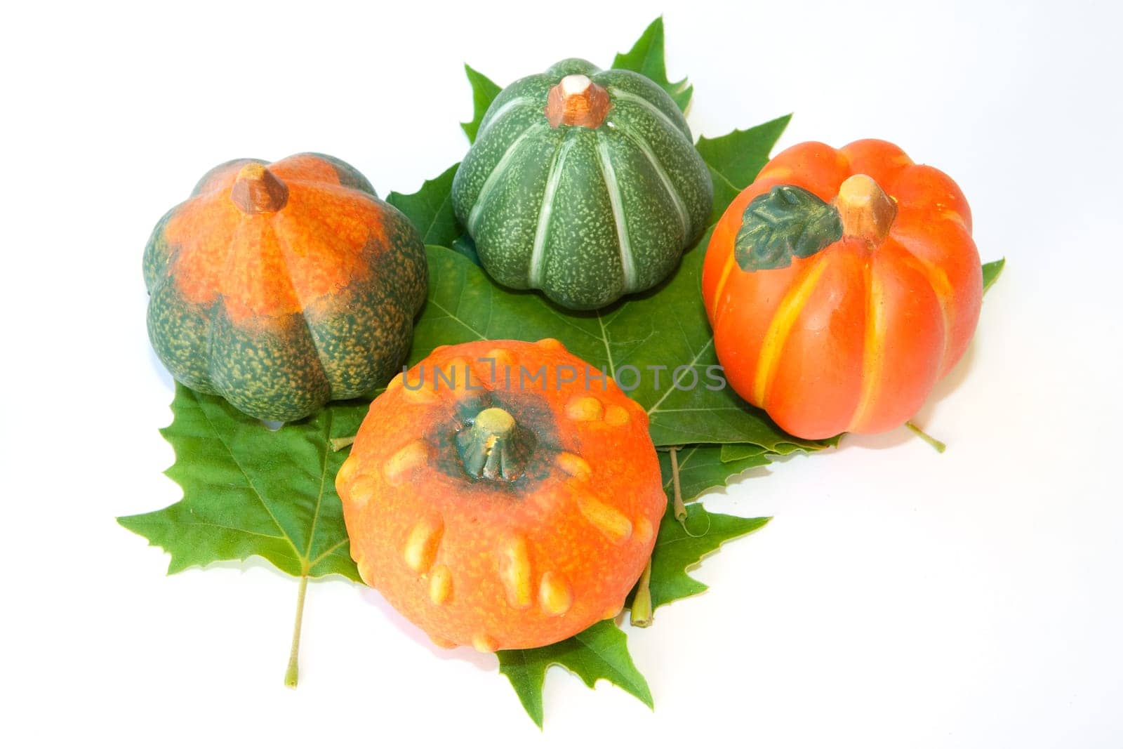 Pumpkins about four green leaf isolated on white background