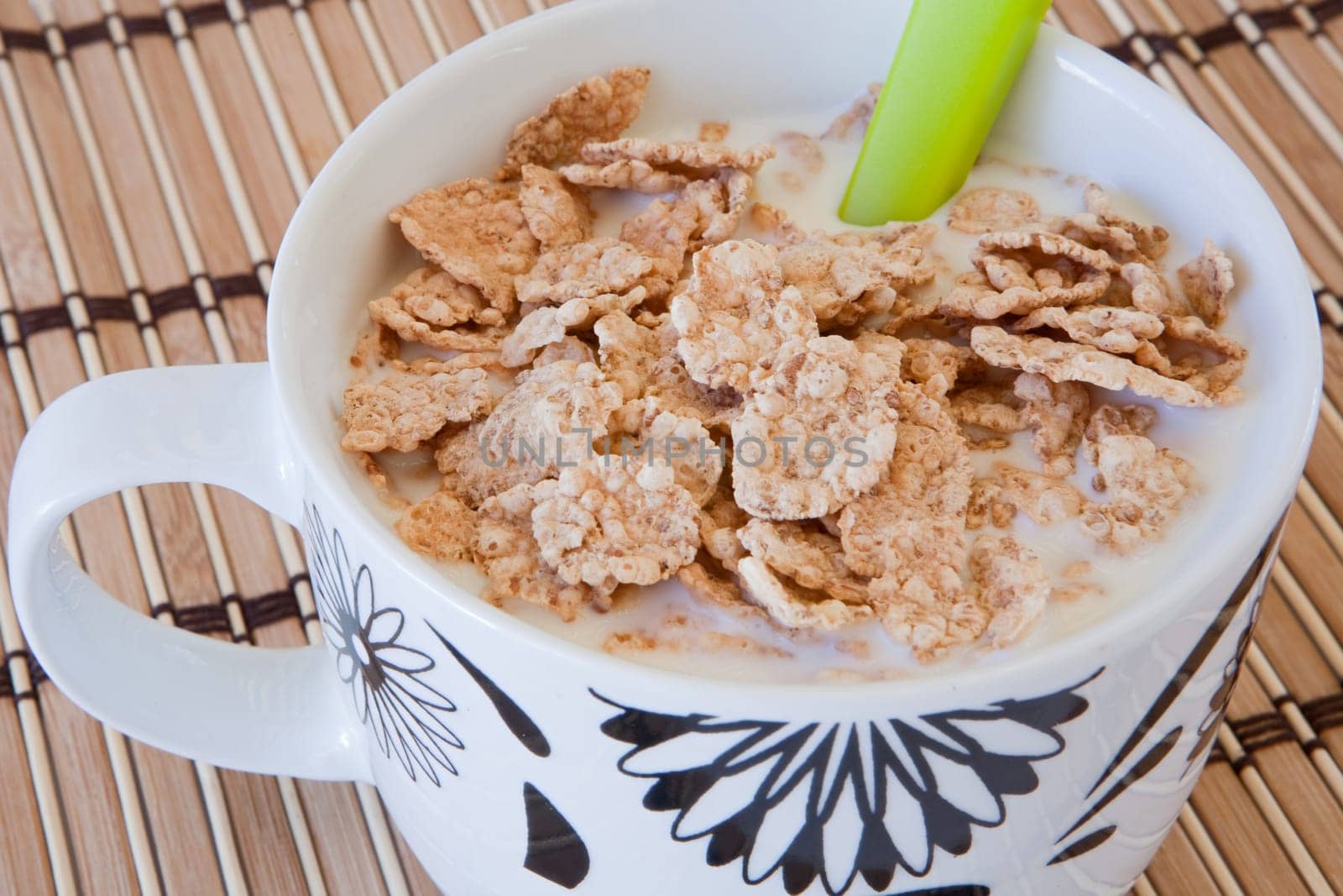 Breakfast bowl of cereal and milk on bamboo tablecloth