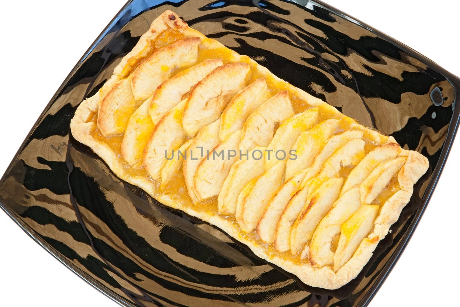 Delicious apple pie on a black plate isolated over white