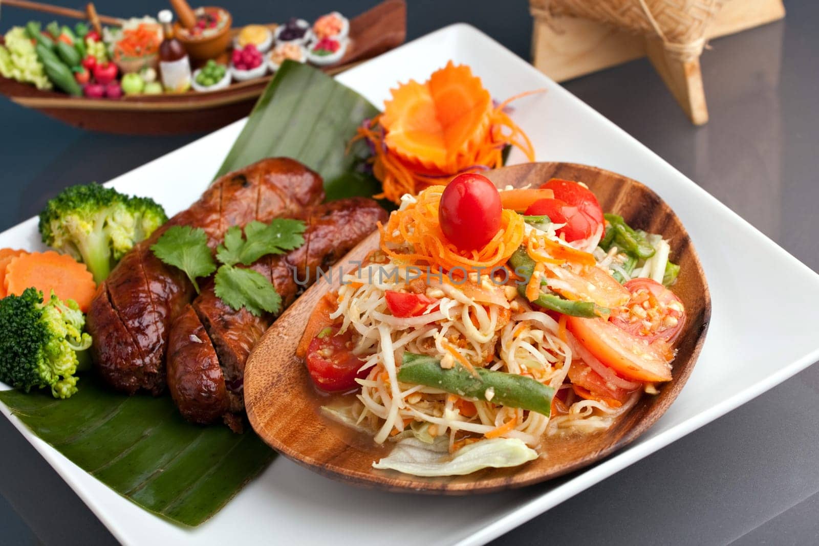 A dish of freshly prepared Thai sausage and som tum green papaya salad.