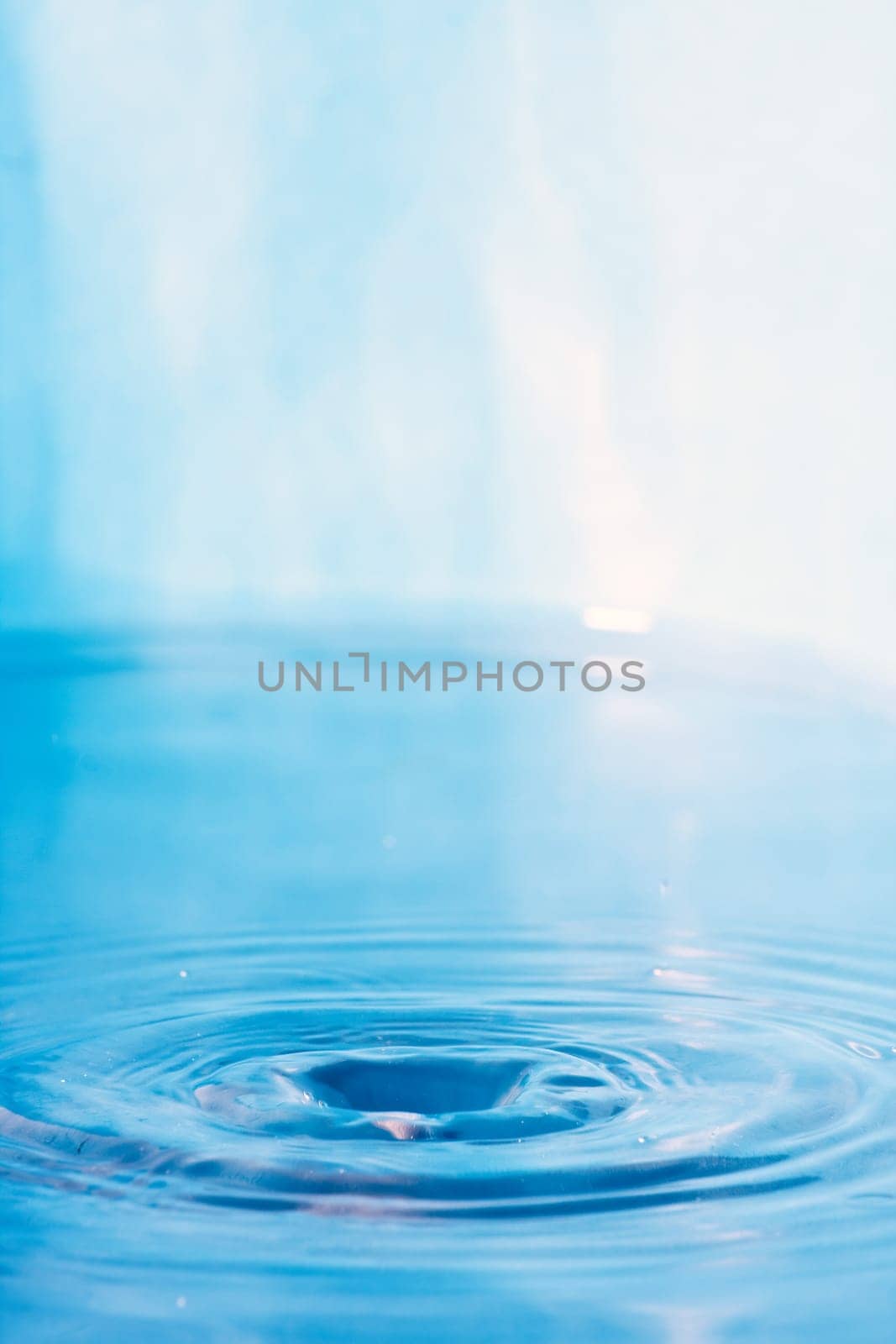 Close up of some clear blue water with circular ripples and plenty of copyspace.