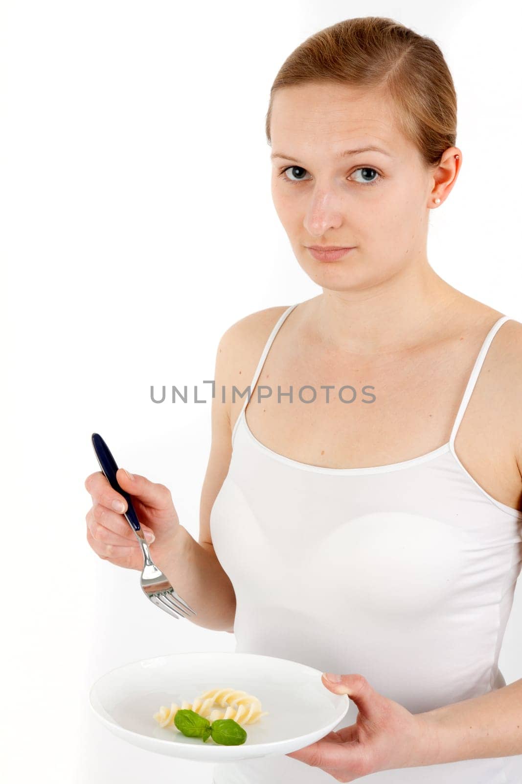 Young woman eating some noodles from almost empty plate