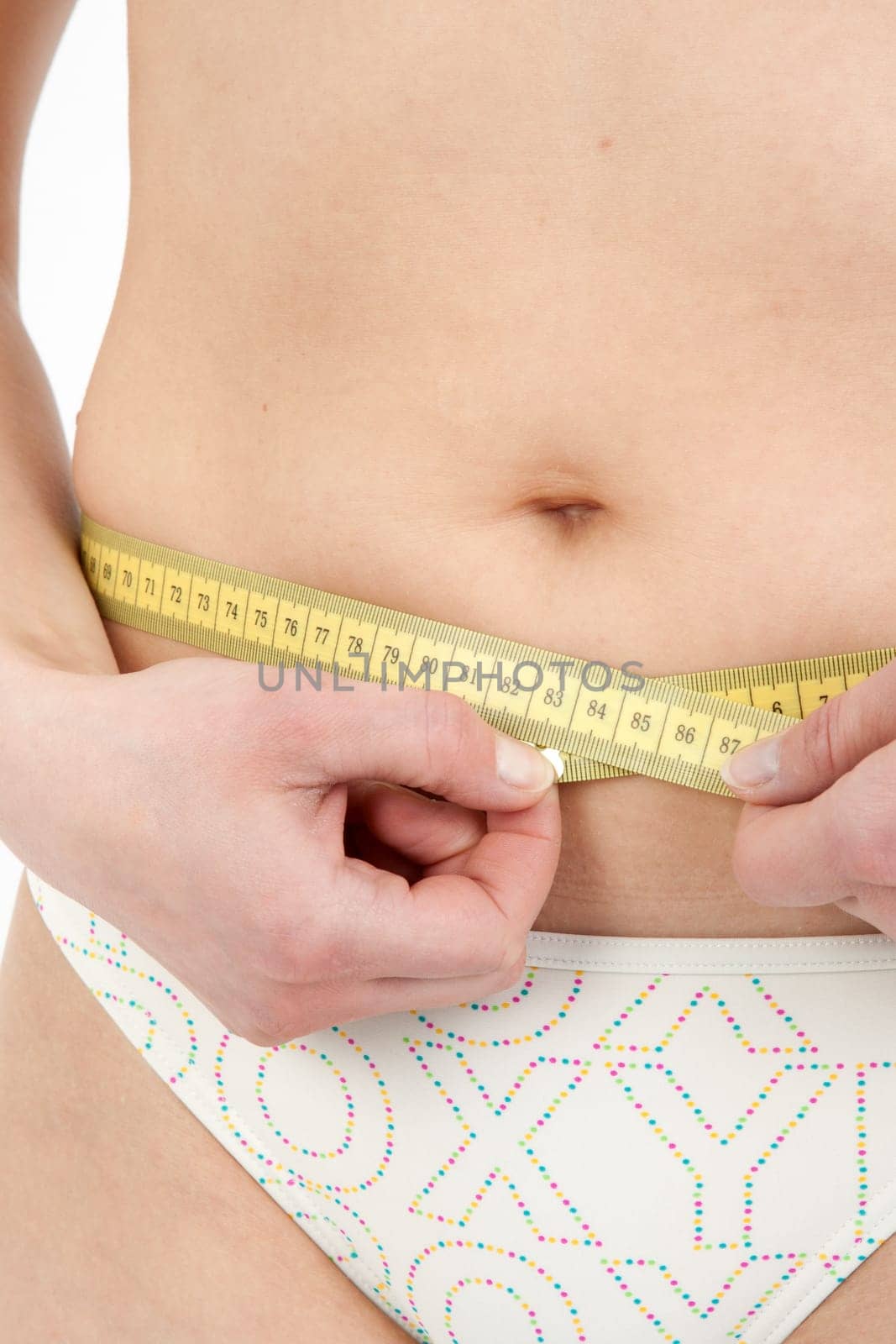 Young woman measuring her abdominal circumference
