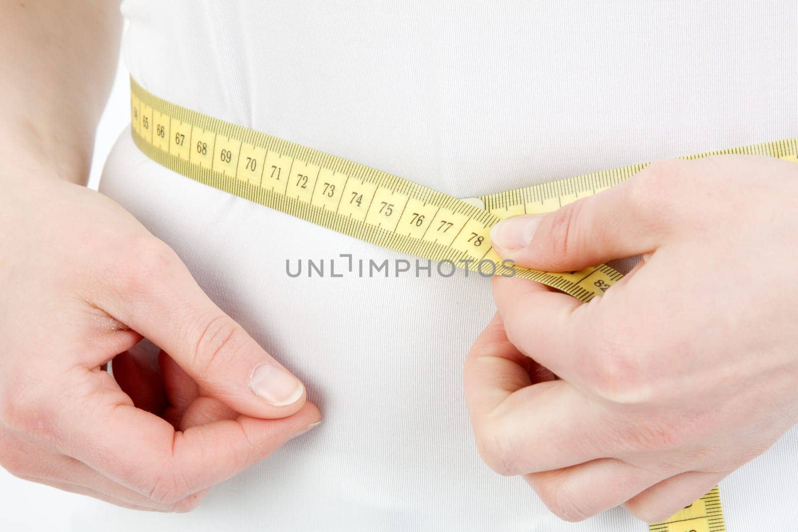 Young woman measuring her abdominal circumference