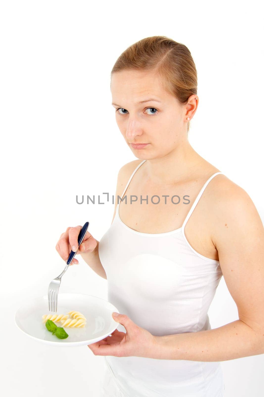 Young woman eating some noodles from almost empty plate