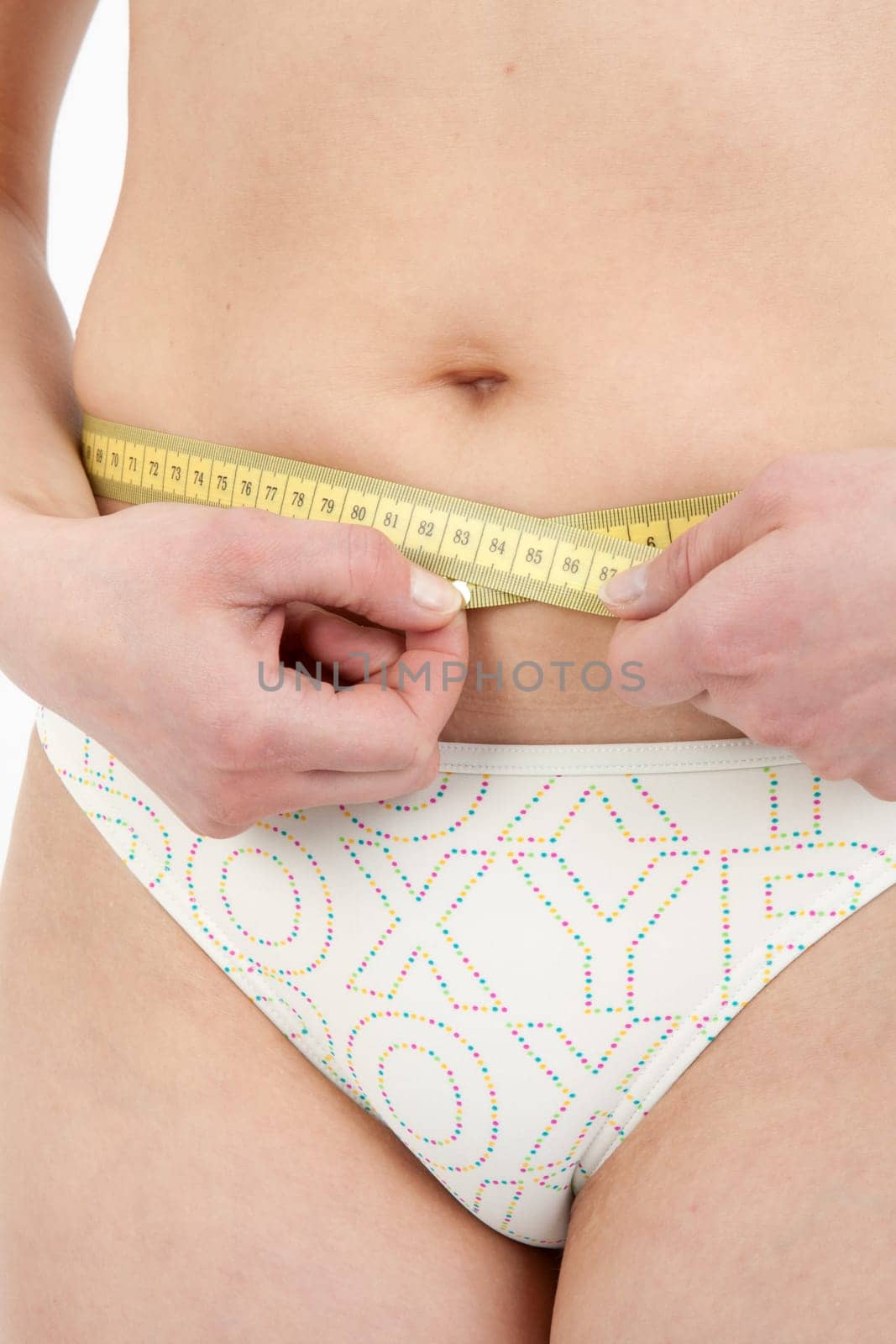 Young woman measuring her abdominal circumference