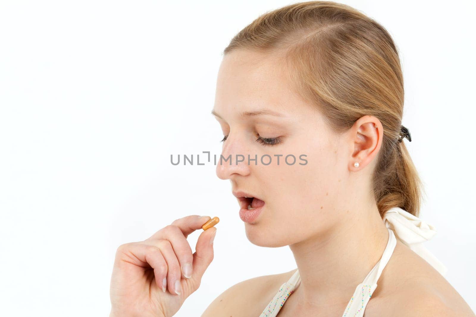 Young woman taking capsule