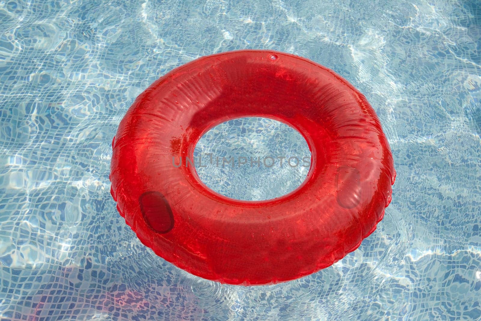 Red float floating in the pool with blue water