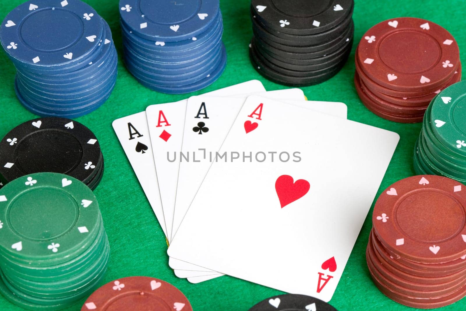 Four aces and poker stacked chips of many colors