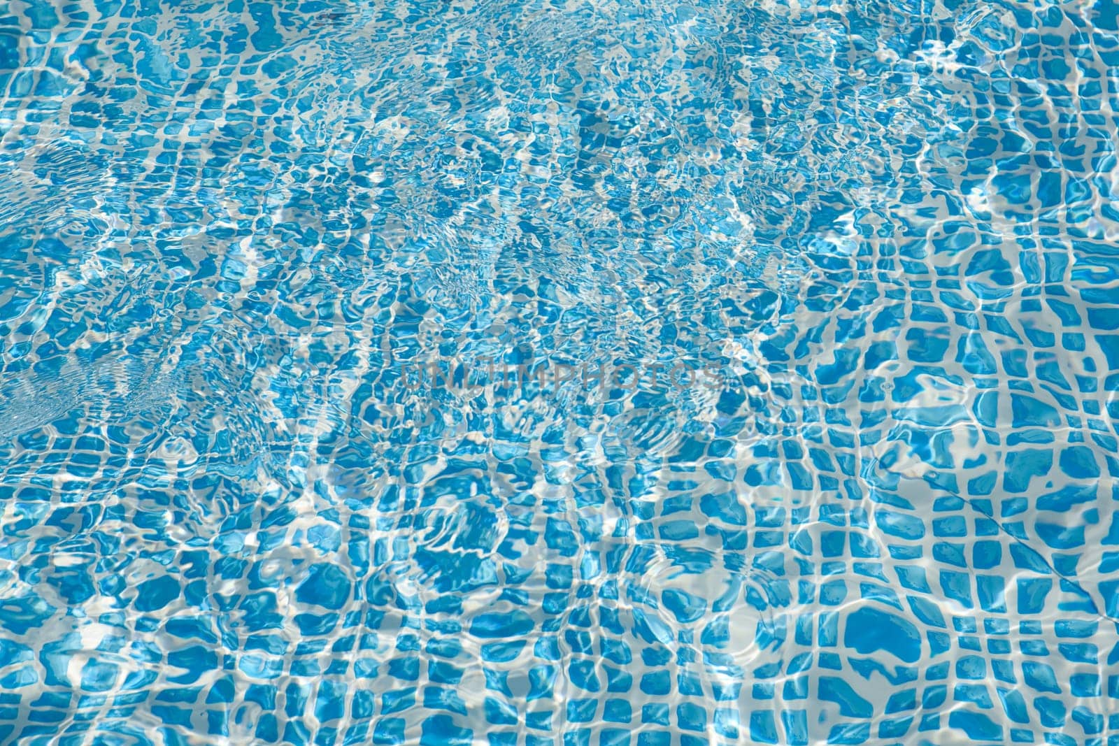 Wall of swimming pool with water of blue color