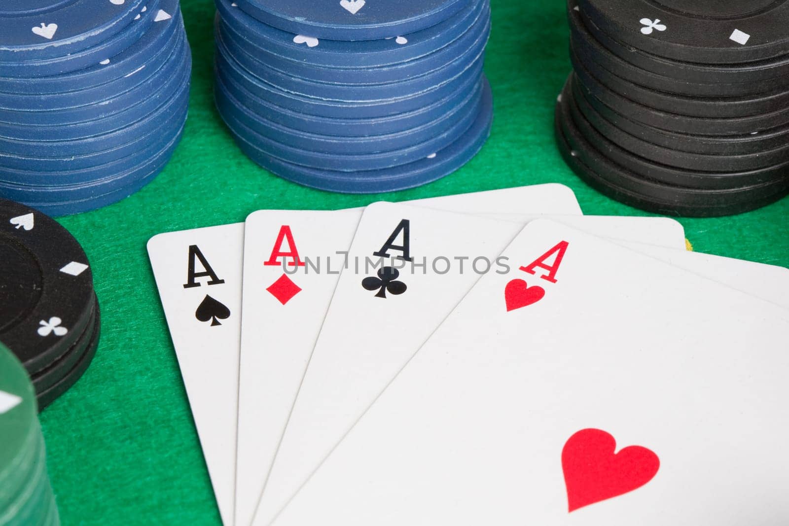 Four aces and poker stacked chips of many colors