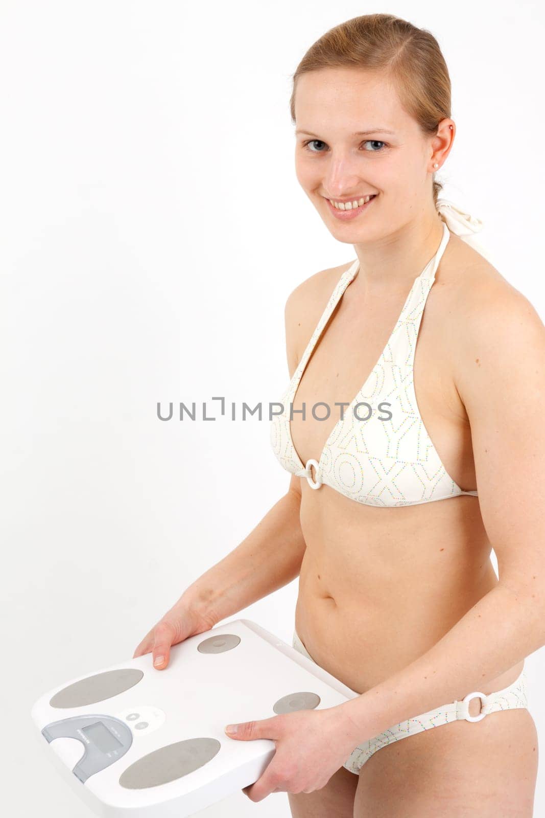 Young woman swaying on a bathroom scale