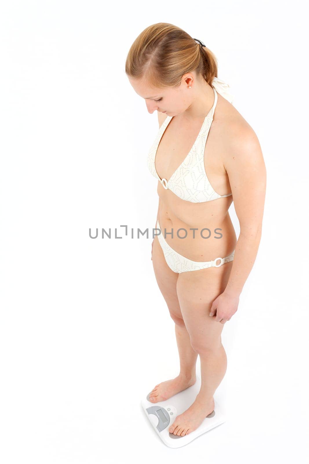 Young woman swaying on a bathroom scale