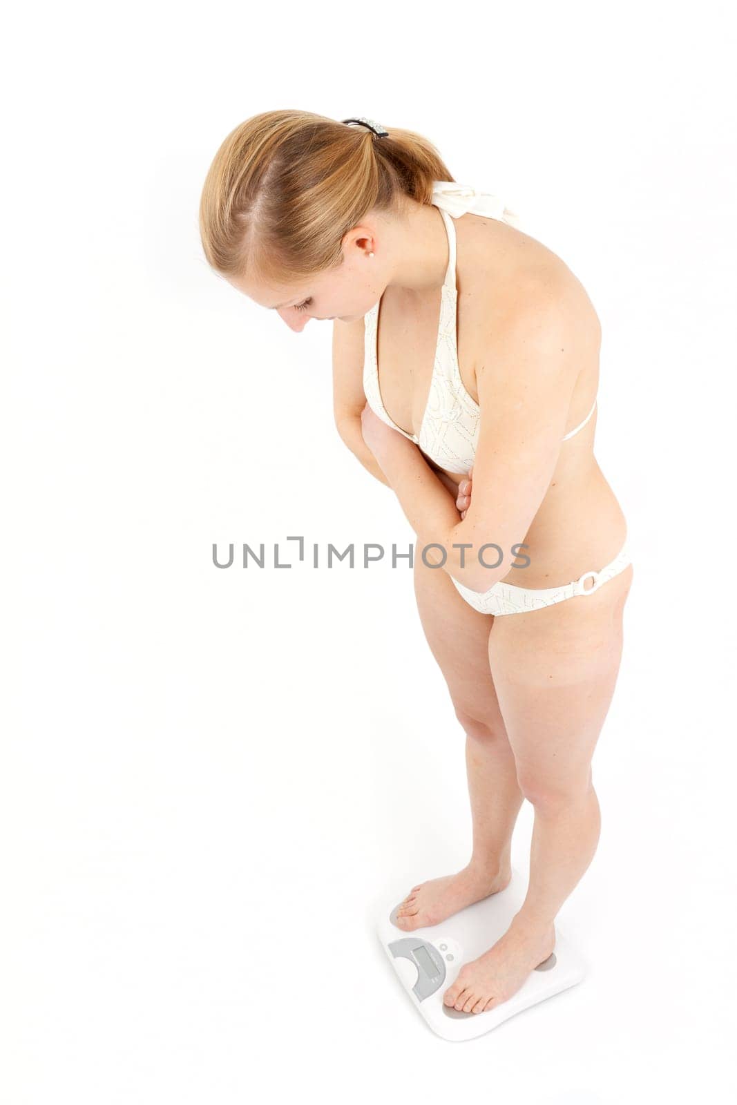 Young woman swaying on a bathroom scale
