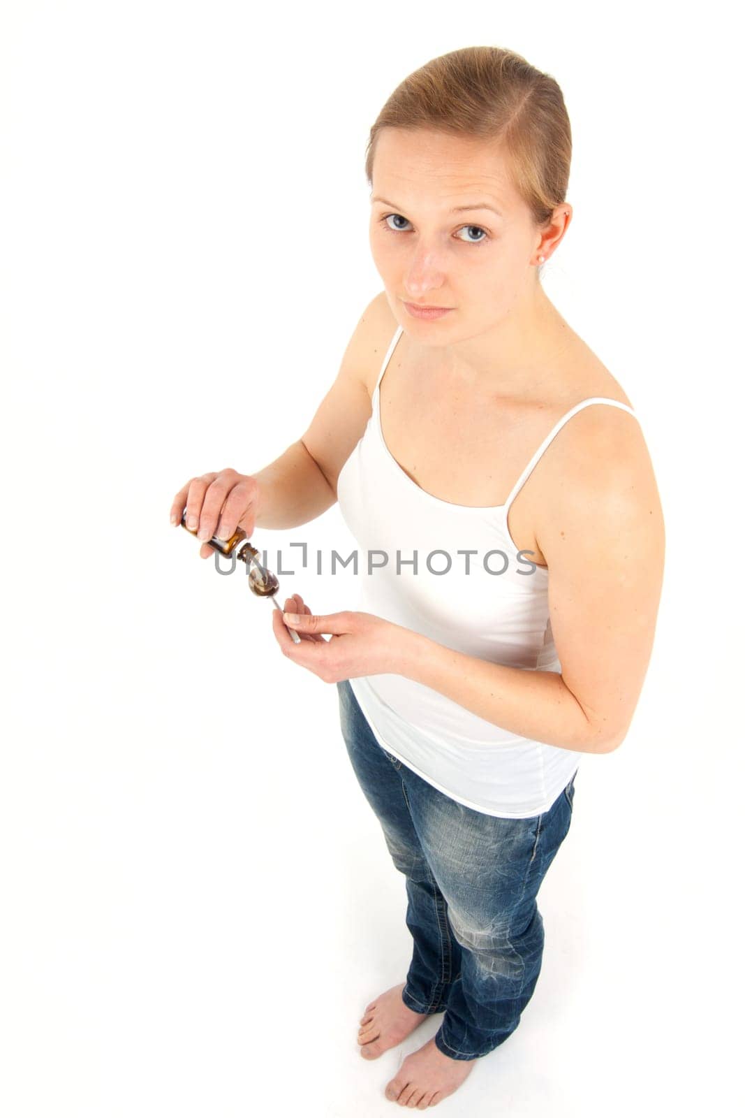 Young woman dripping medicine into a spoon