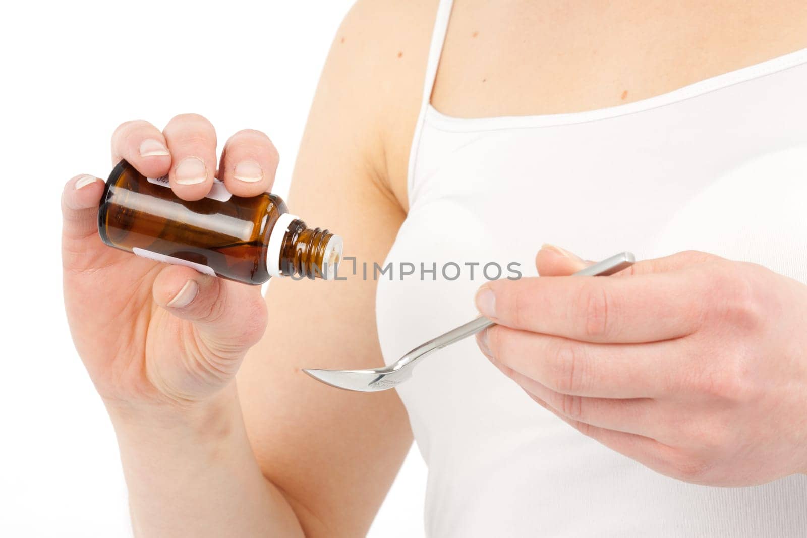 Young woman dripping medicine into a spoon