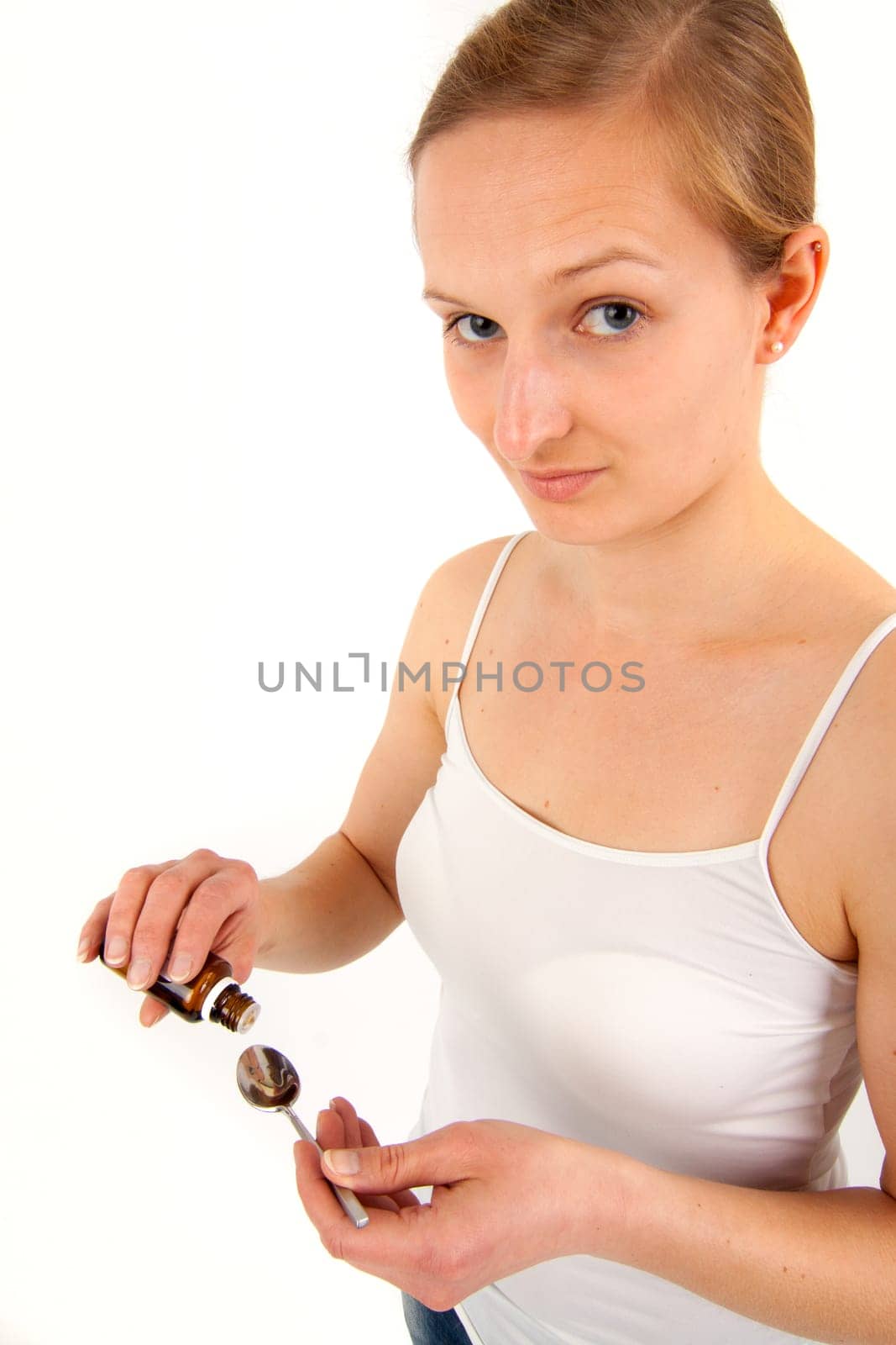 Young woman dripping medicine into a spoon