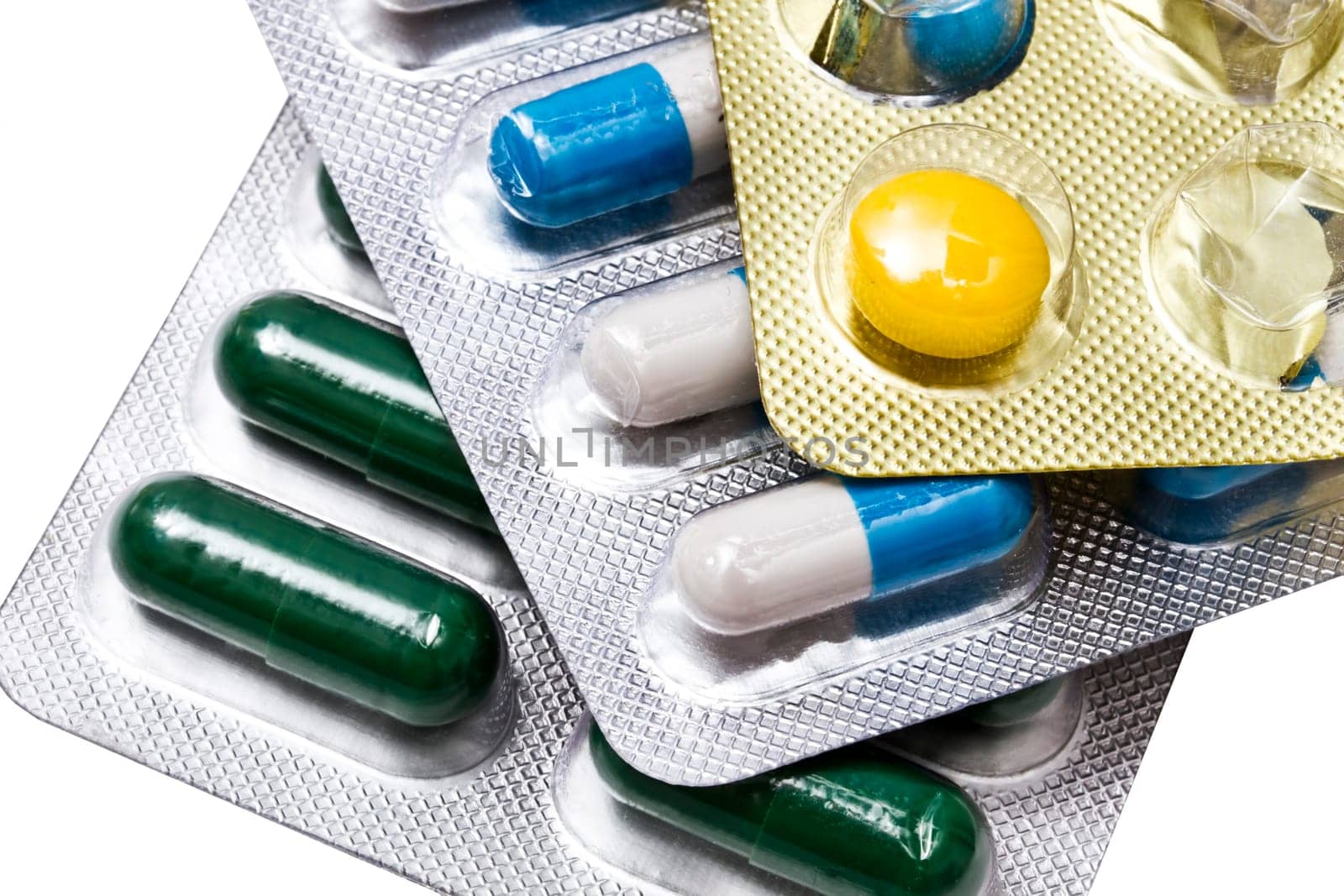 Different capsules and pills closeup on white background