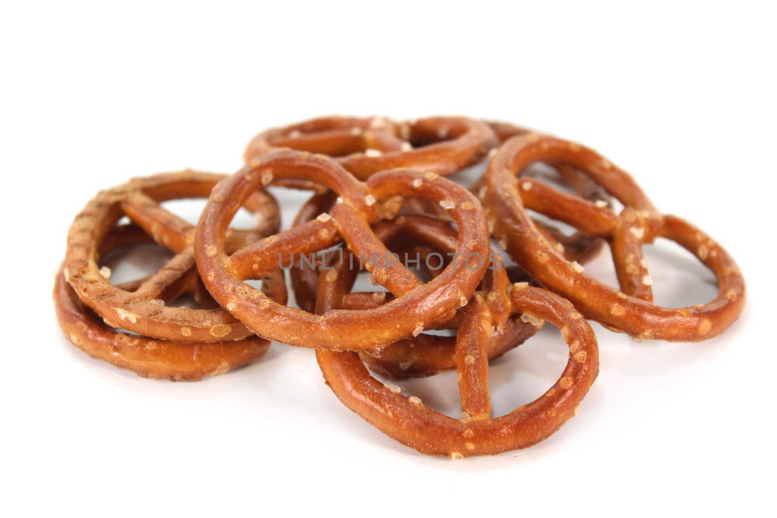 a handful of salted pretzels against a white background