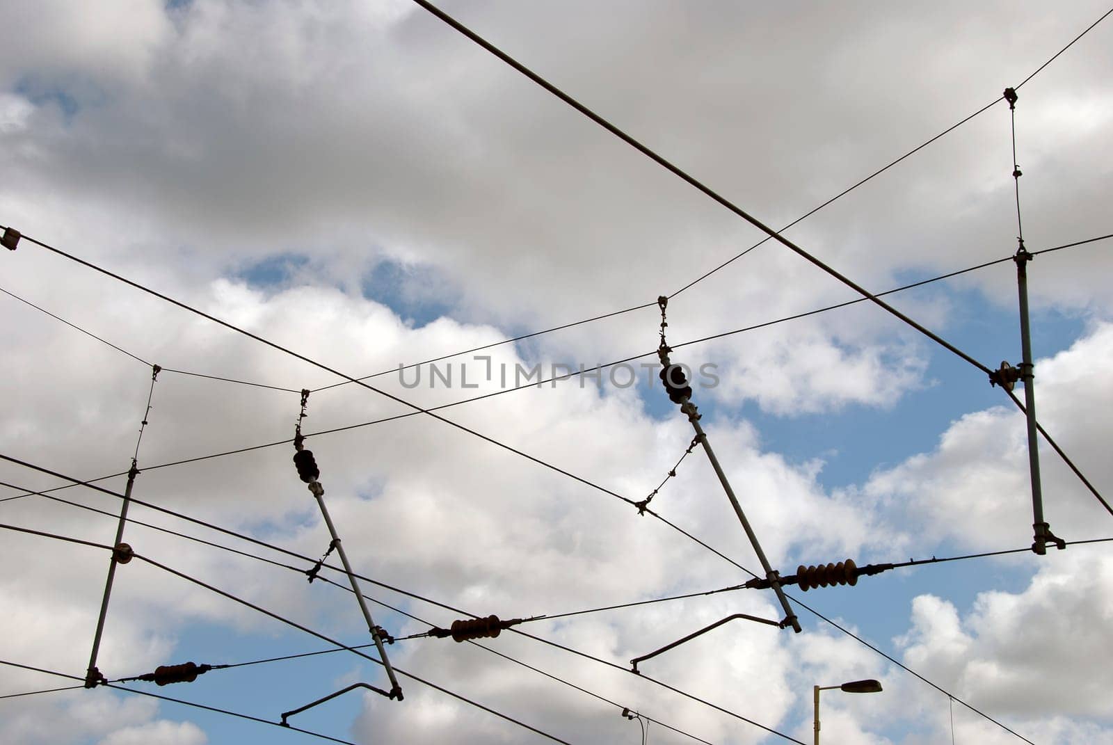 The overhead power cables of an electric railway line in Yorkshire England against a blue sky