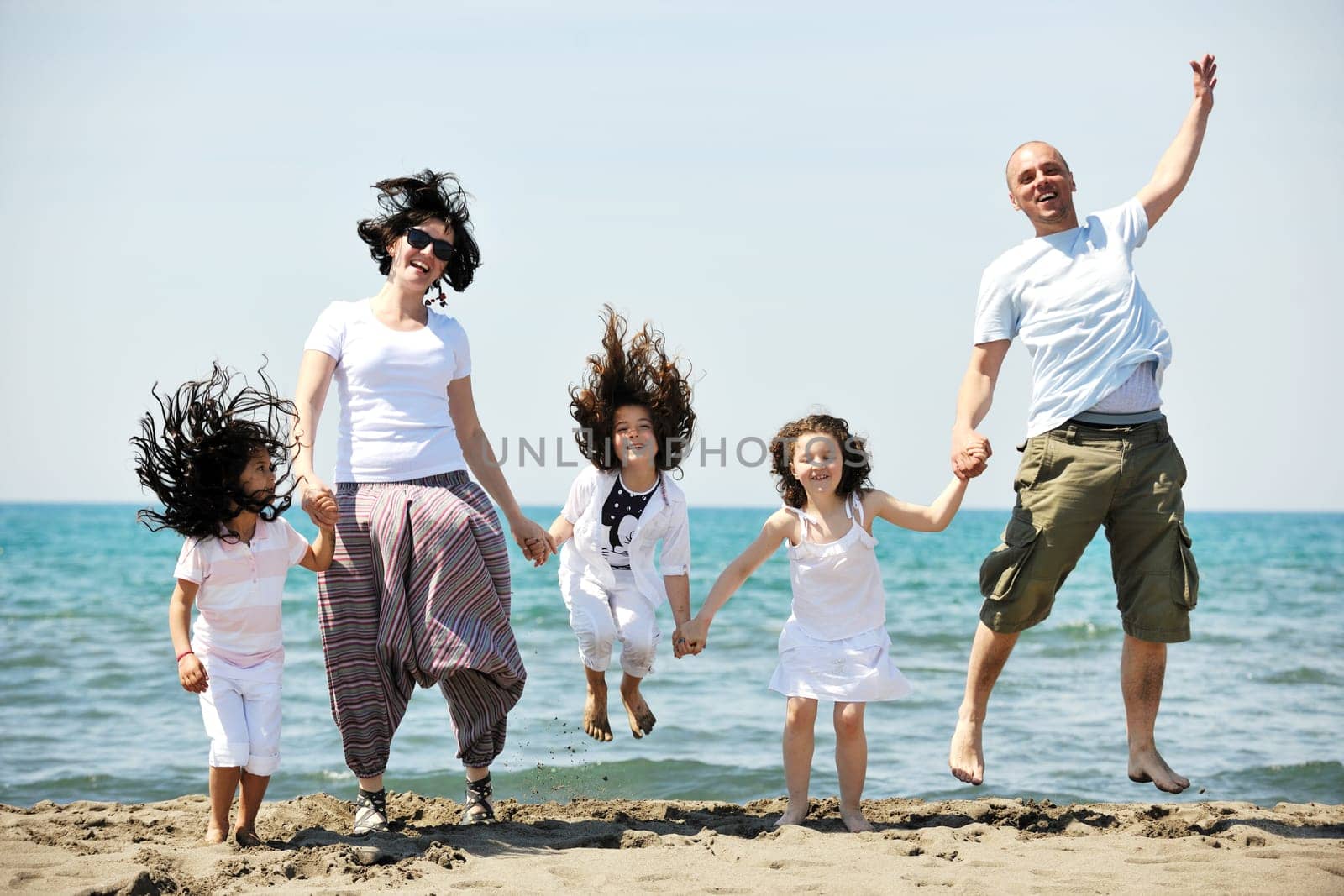 happy young family have fun and live healthy lifestyle on beach