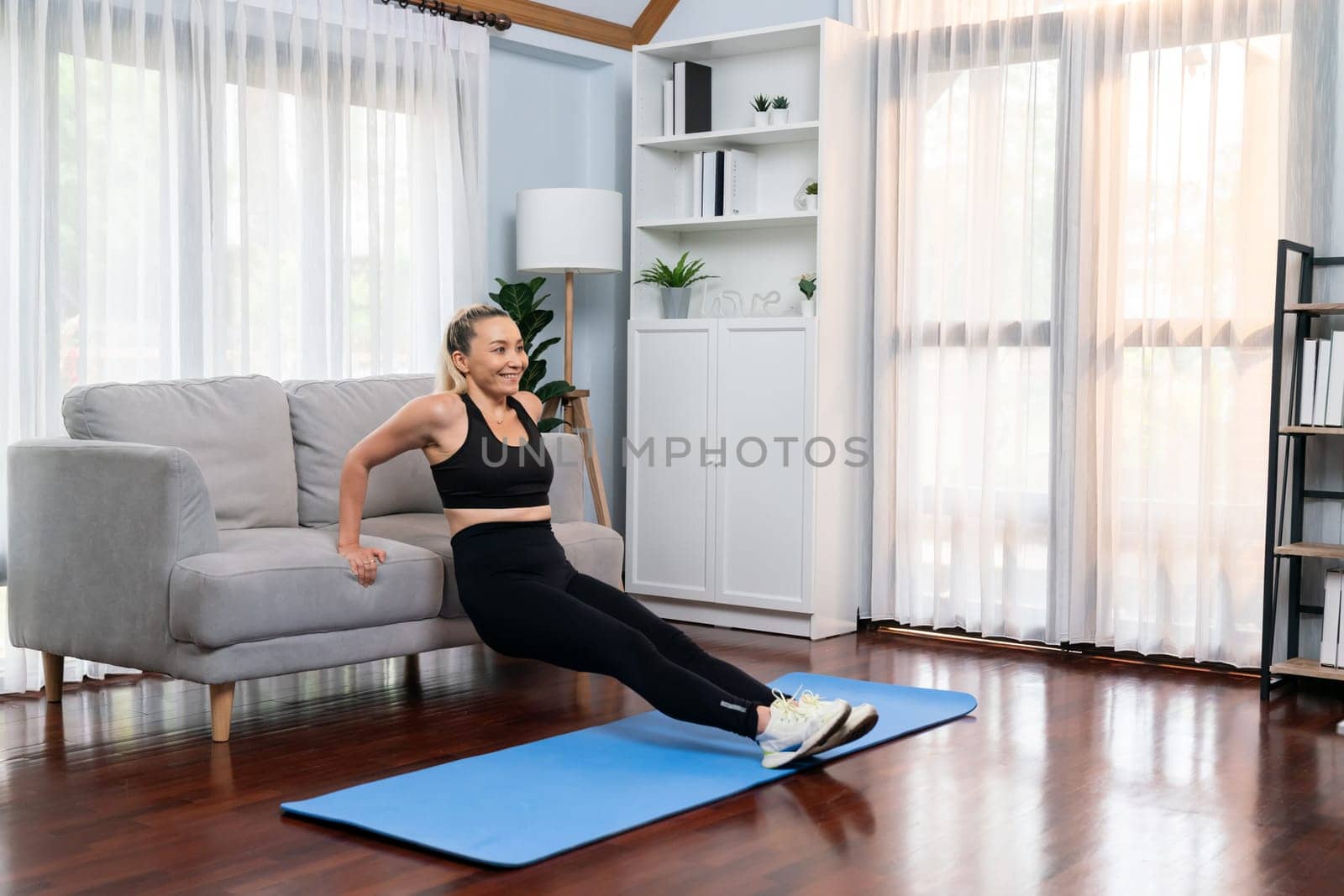 Athletic and active senior woman using furniture for effective targeting muscle with push up at home exercise as concept of healthy fit body lifestyle after retirement. Clout