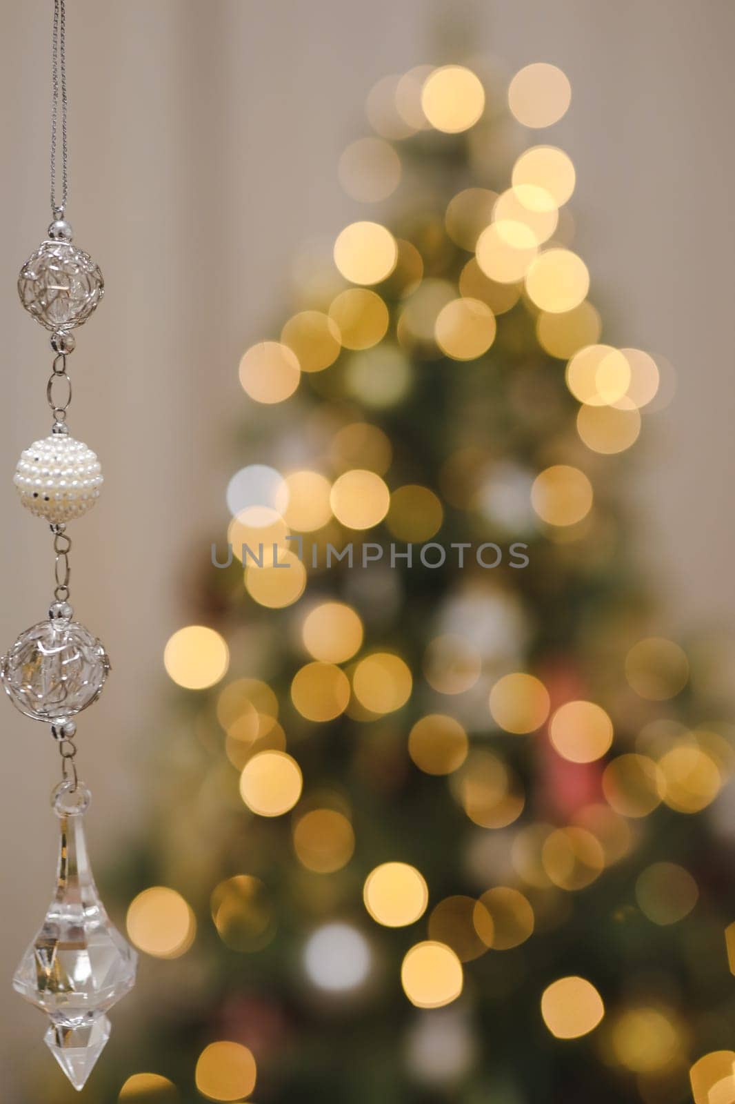 Christmas and New years eve Background. Close up of balls on christmas tree. Bokeh garlands in the background. New Year concept. Decorated Christmas tree on blurred, sparkling and fairy background