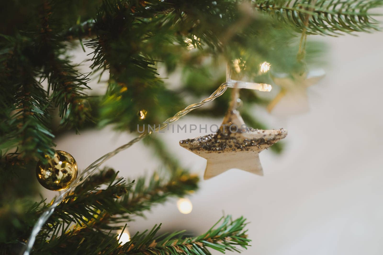 Christmas and New years eve Background. Close up of balls on christmas tree. Bokeh garlands in the background. New Year concept. Decorated Christmas tree on blurred, sparkling and fairy background