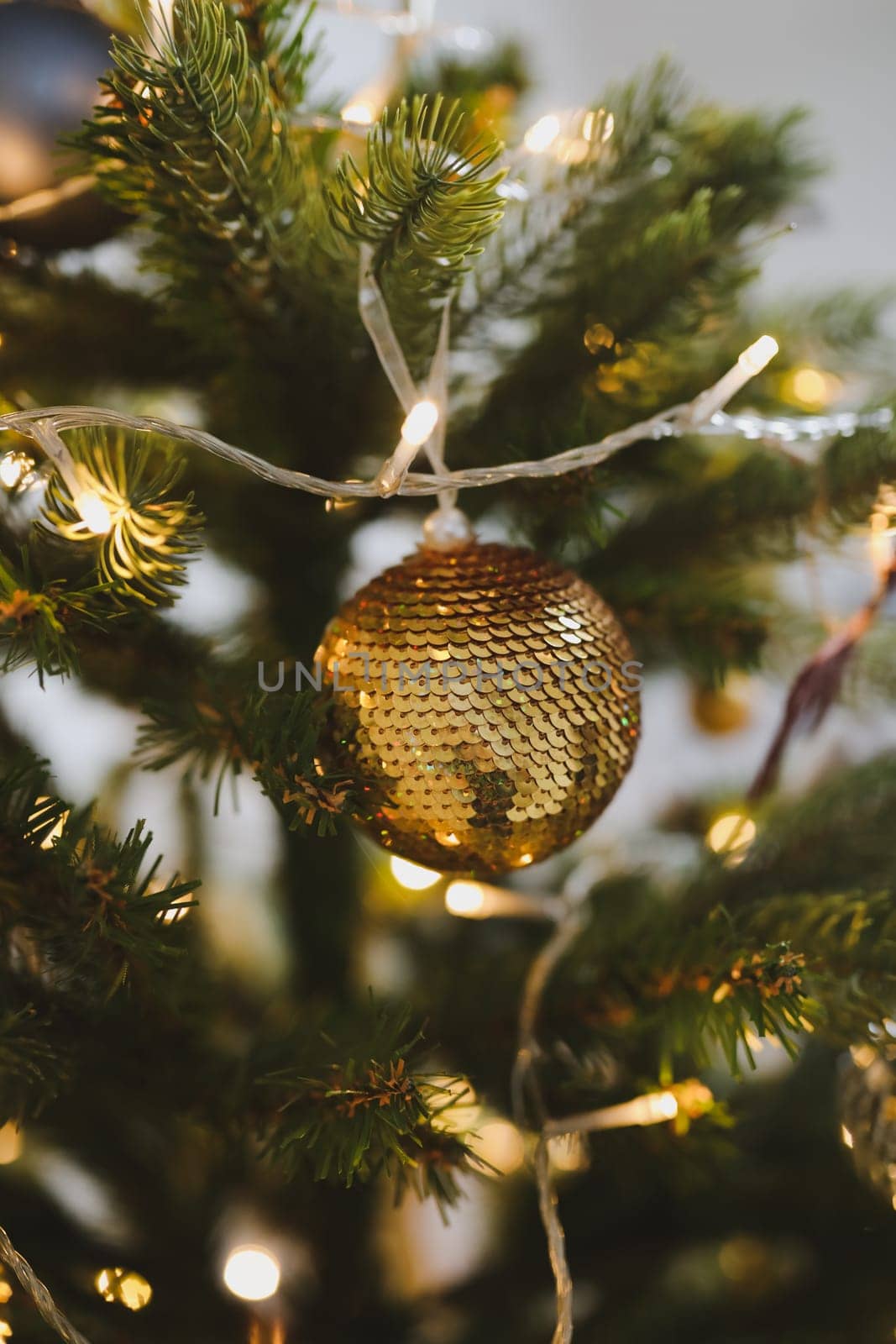 Christmas and New years eve Background. Close up of balls on christmas tree. Bokeh garlands in the background. New Year concept. Decorated Christmas tree on blurred, sparkling and fairy background