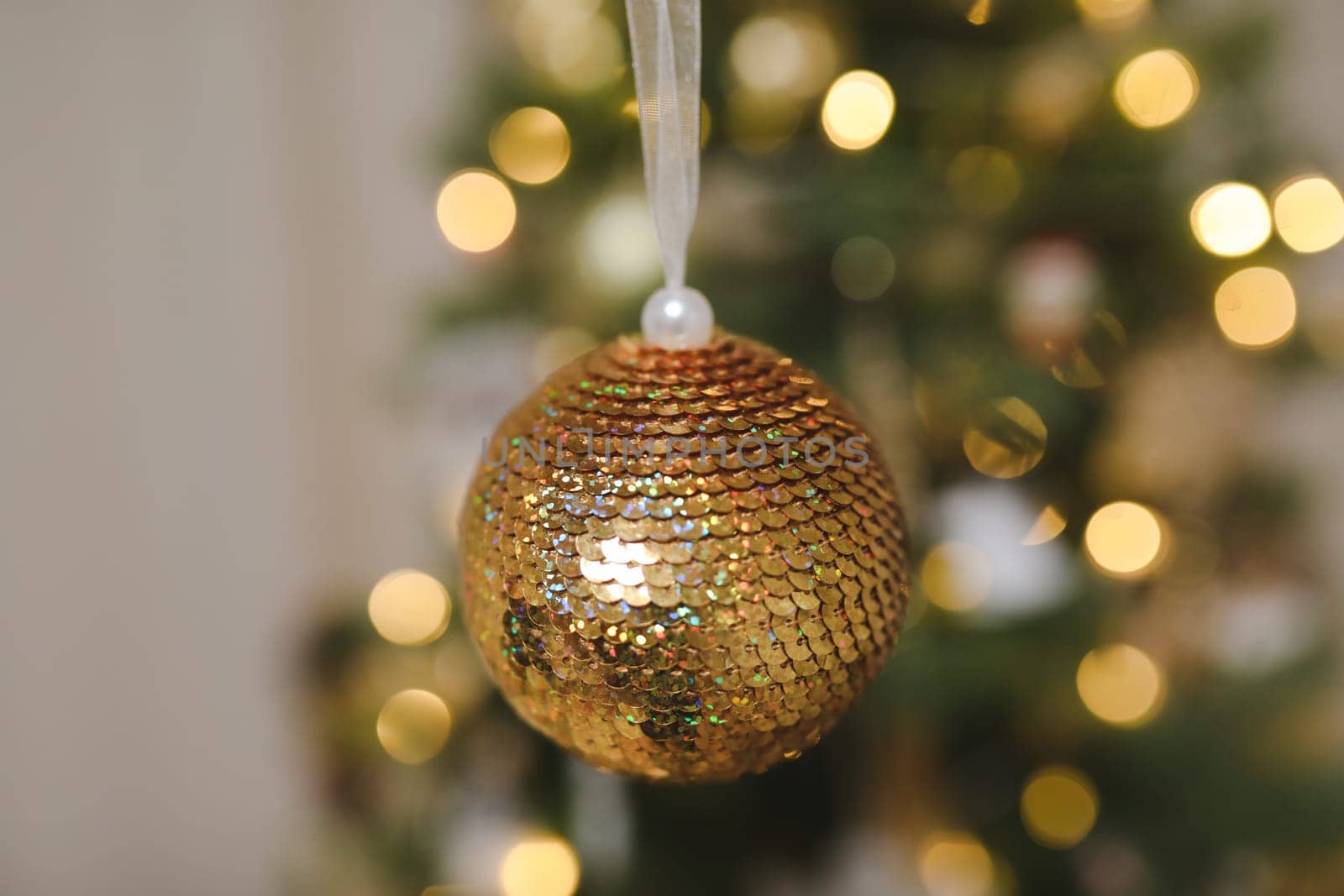 Christmas and New years eve Background. Close up of balls on christmas tree. Bokeh garlands in the background. New Year concept. Decorated Christmas tree on blurred, sparkling and fairy background