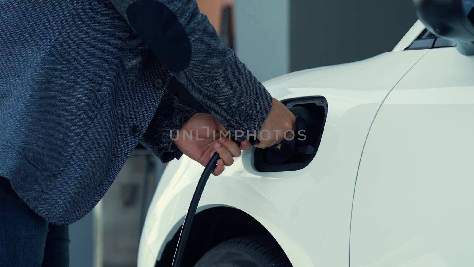 Progressive idea of charging electric vehicle via cable from charging station. by biancoblue