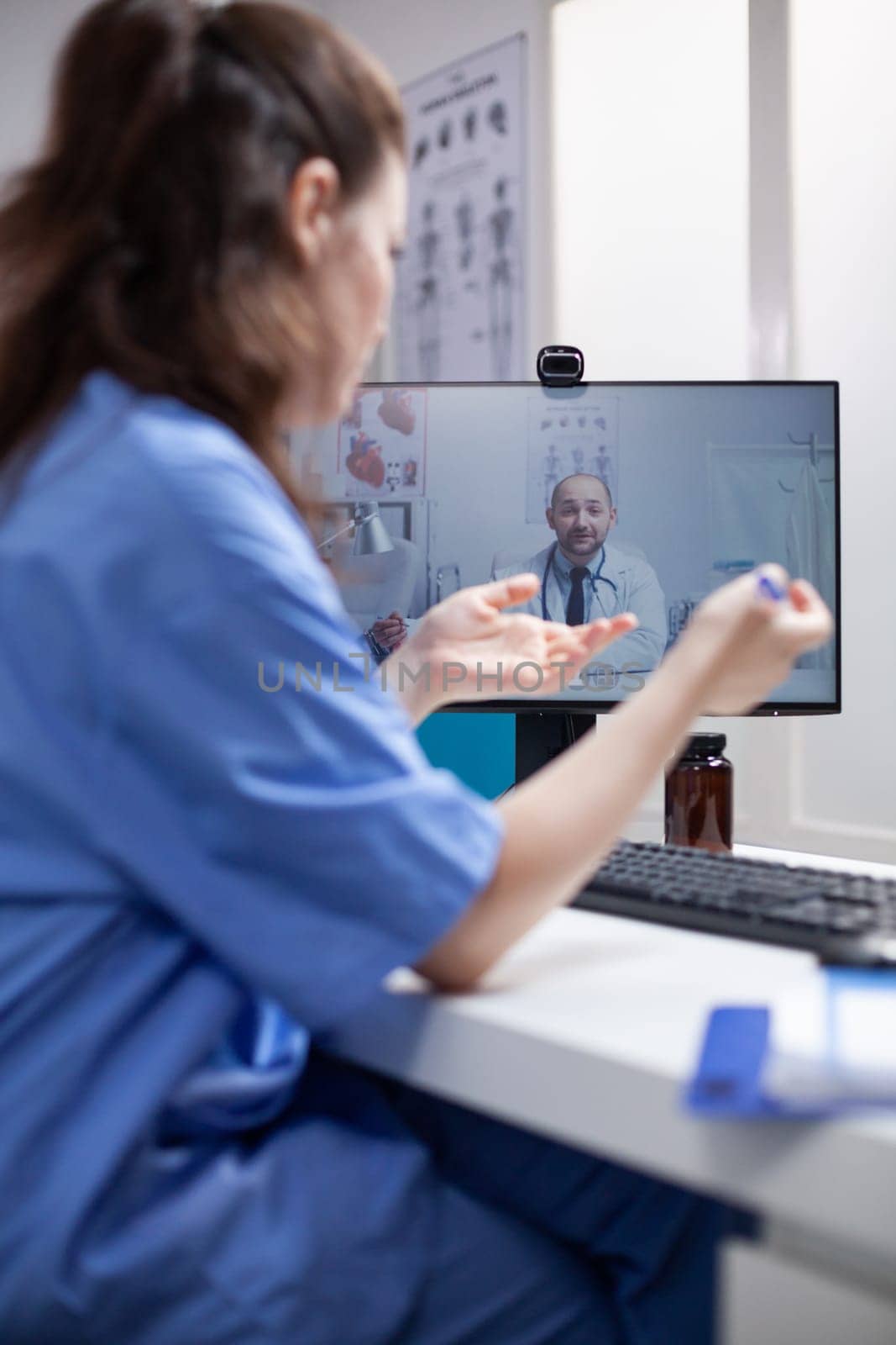 Nurse in telemedicine call with doctor by DCStudio