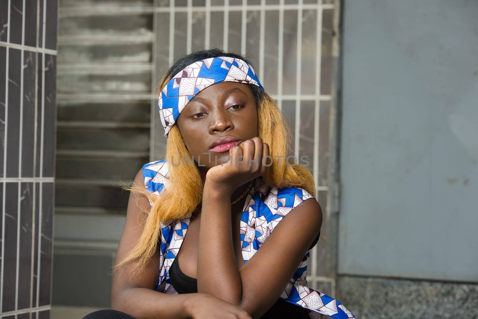 sad young woman in trouble lost in thought sitting outside the hand on the chin .concept unresolved problem