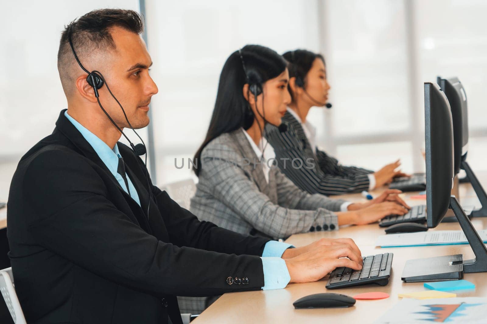 Business people wearing headset working in office to support remote customer or colleague. Call center, telemarketing, customer support agent provide service on telephone video conference call. Jivy