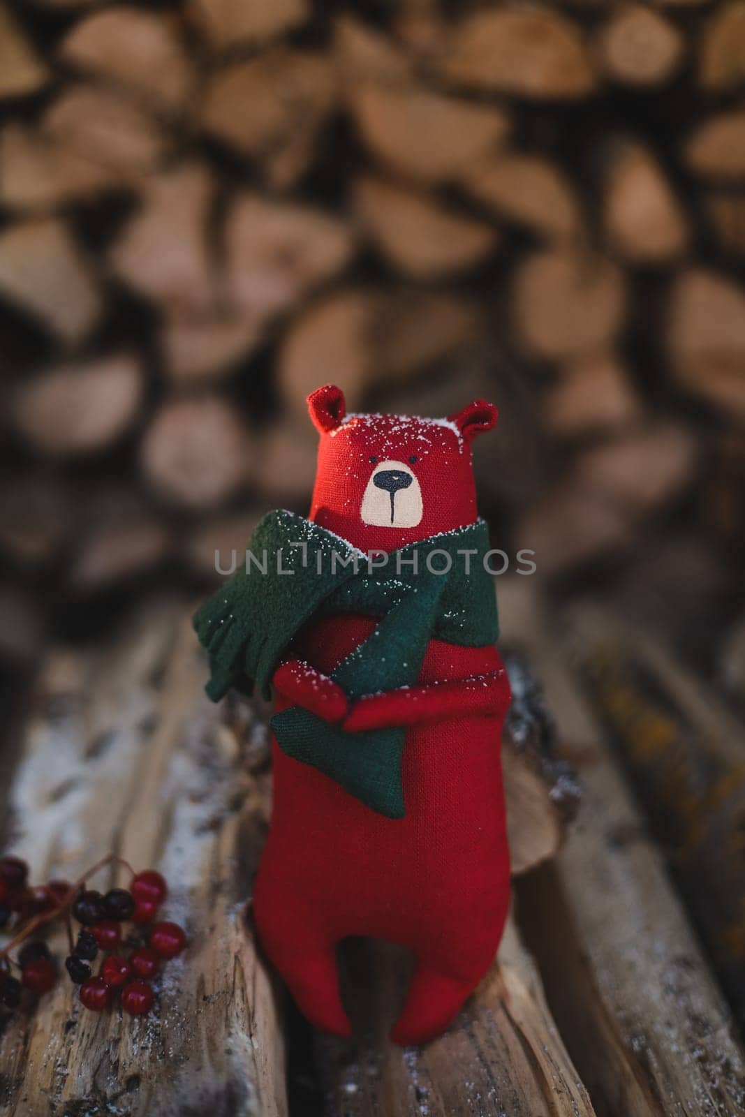 Christmas, New Year, Winter concept. Cozy composition with toy bear on wooden logs under snow.