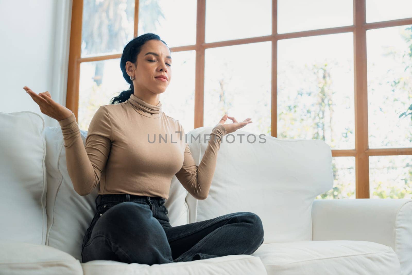 Young African American woman practice crucial mindful meditation at home living room for improving mental health strength and peaceful beautiful living