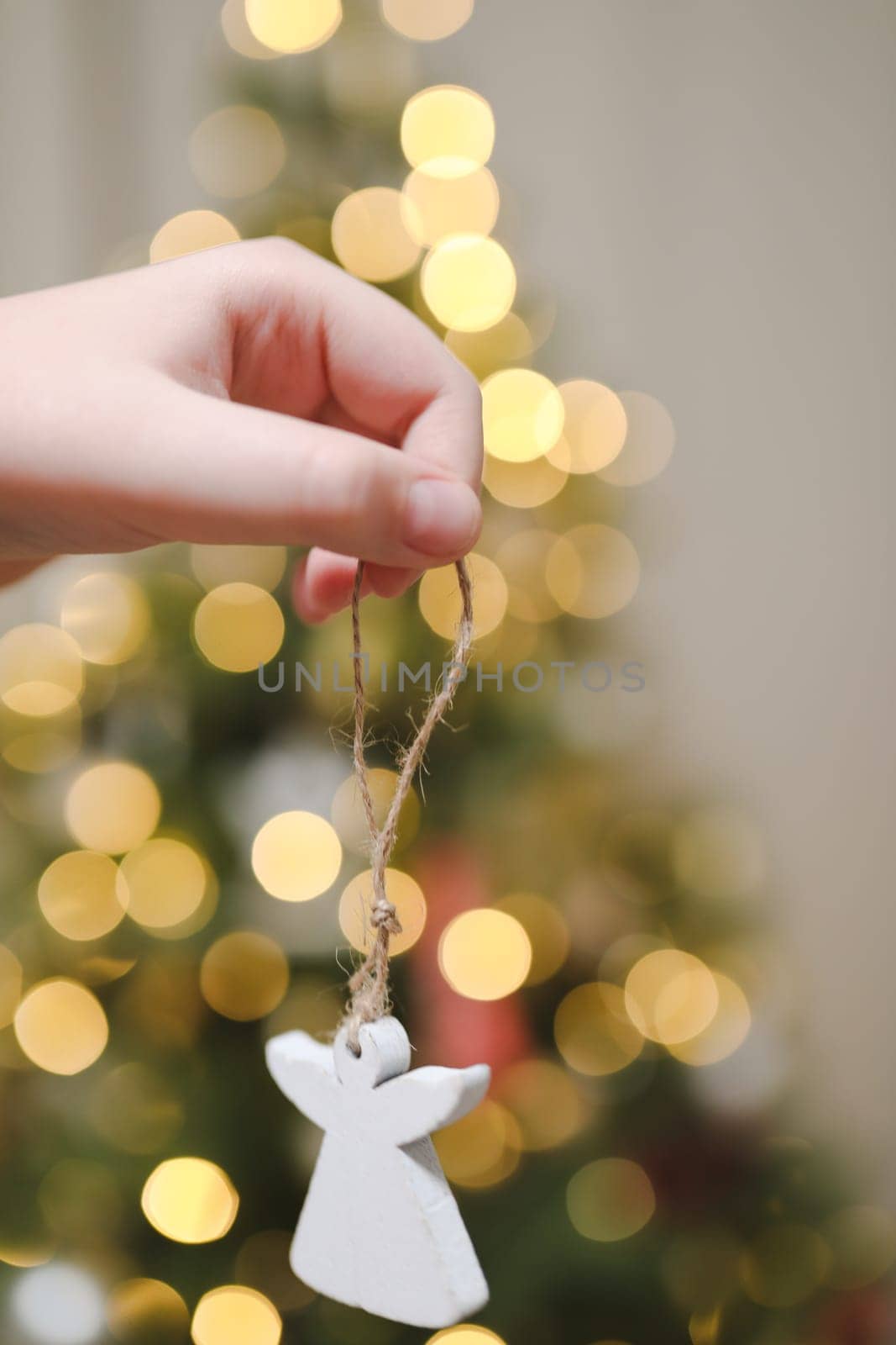 Decorating Christmas tree, hand holding Christmas toy. Holiday, Christmas and New Year celebration concept by paralisart