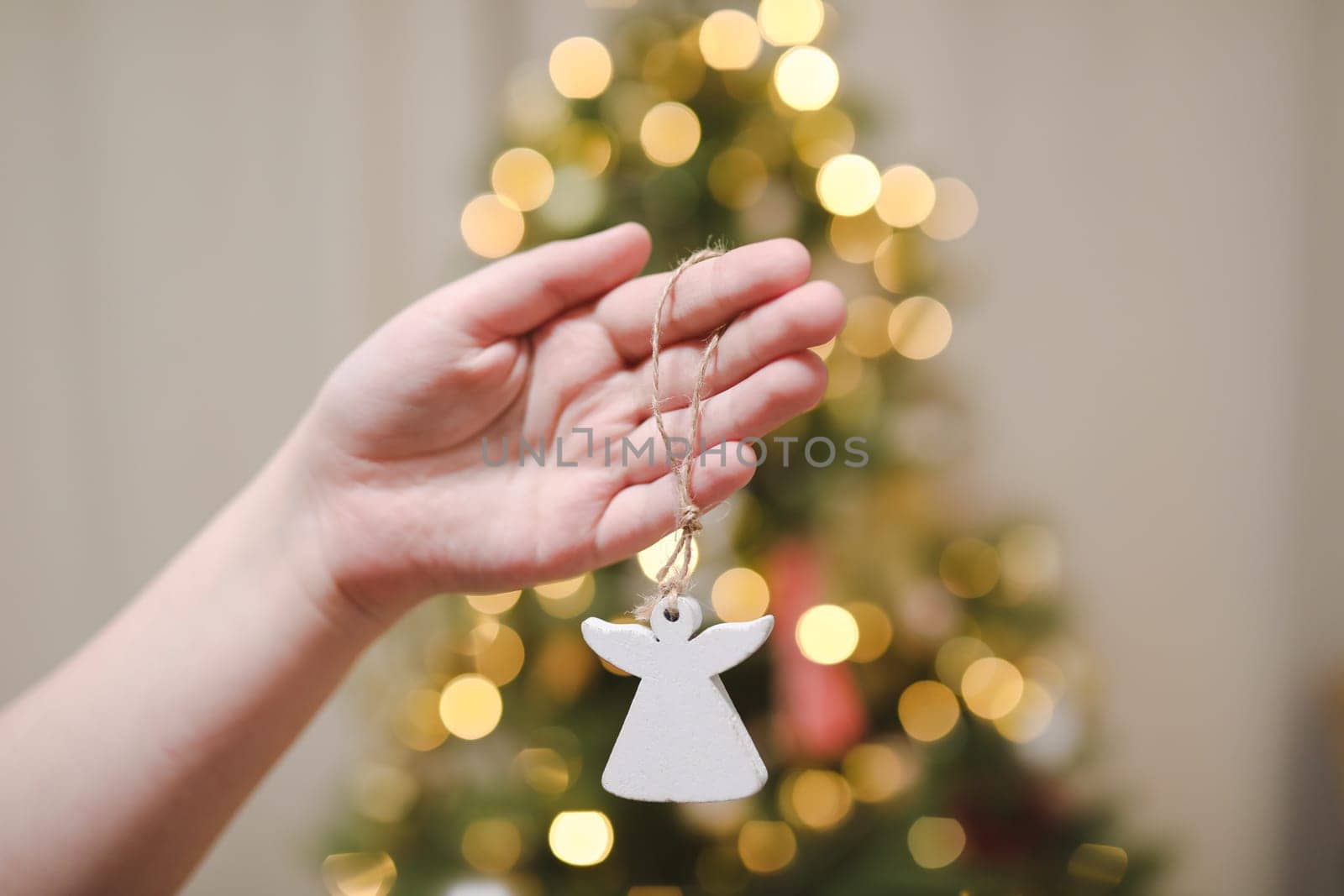 Decorating Christmas tree, hand holding Christmas toy. Holiday, Christmas and New Year celebration concept by paralisart