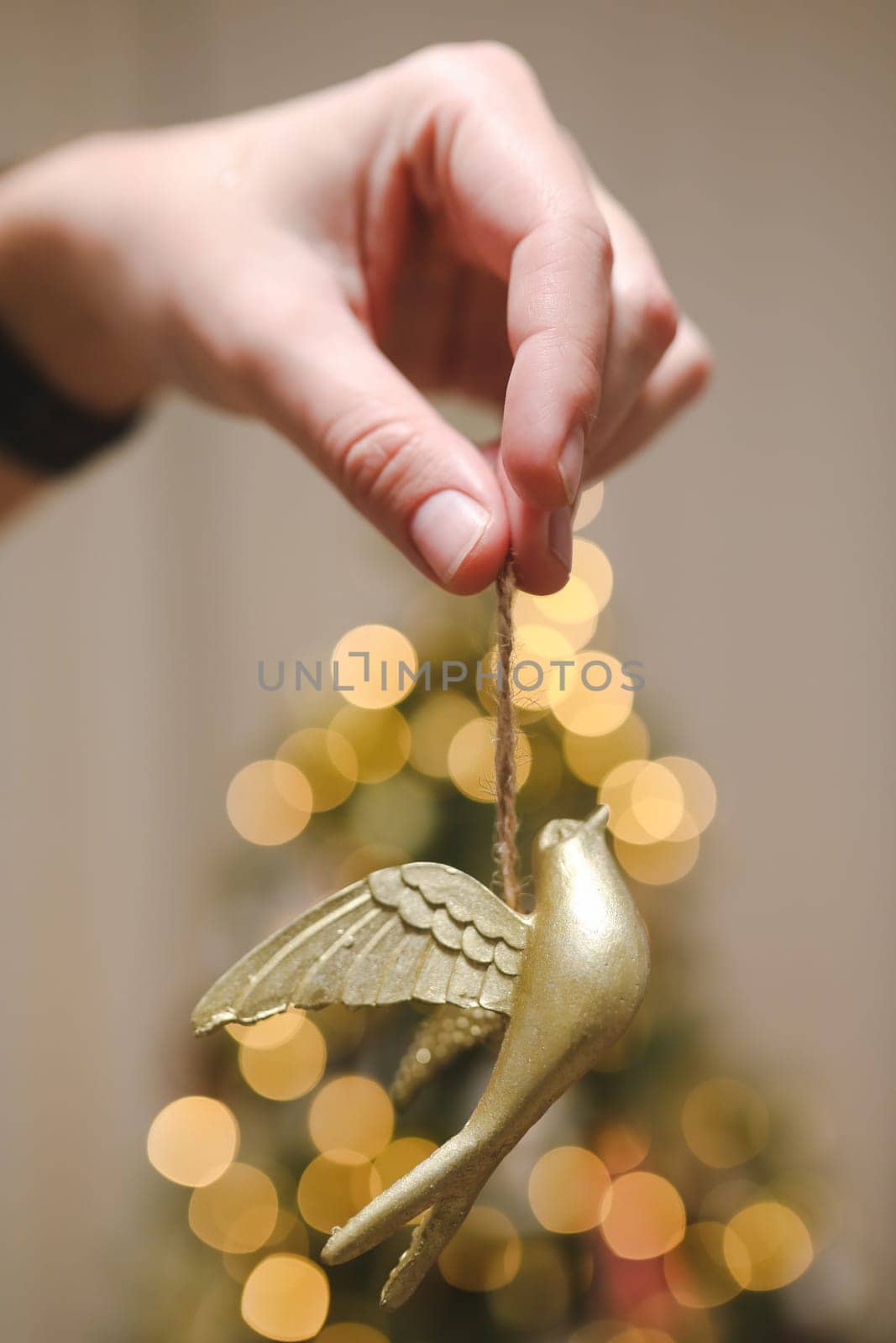 Decorating Christmas tree, holding Christmas toy in a hand. Holiday, Christmas and New Year family celebration concept.