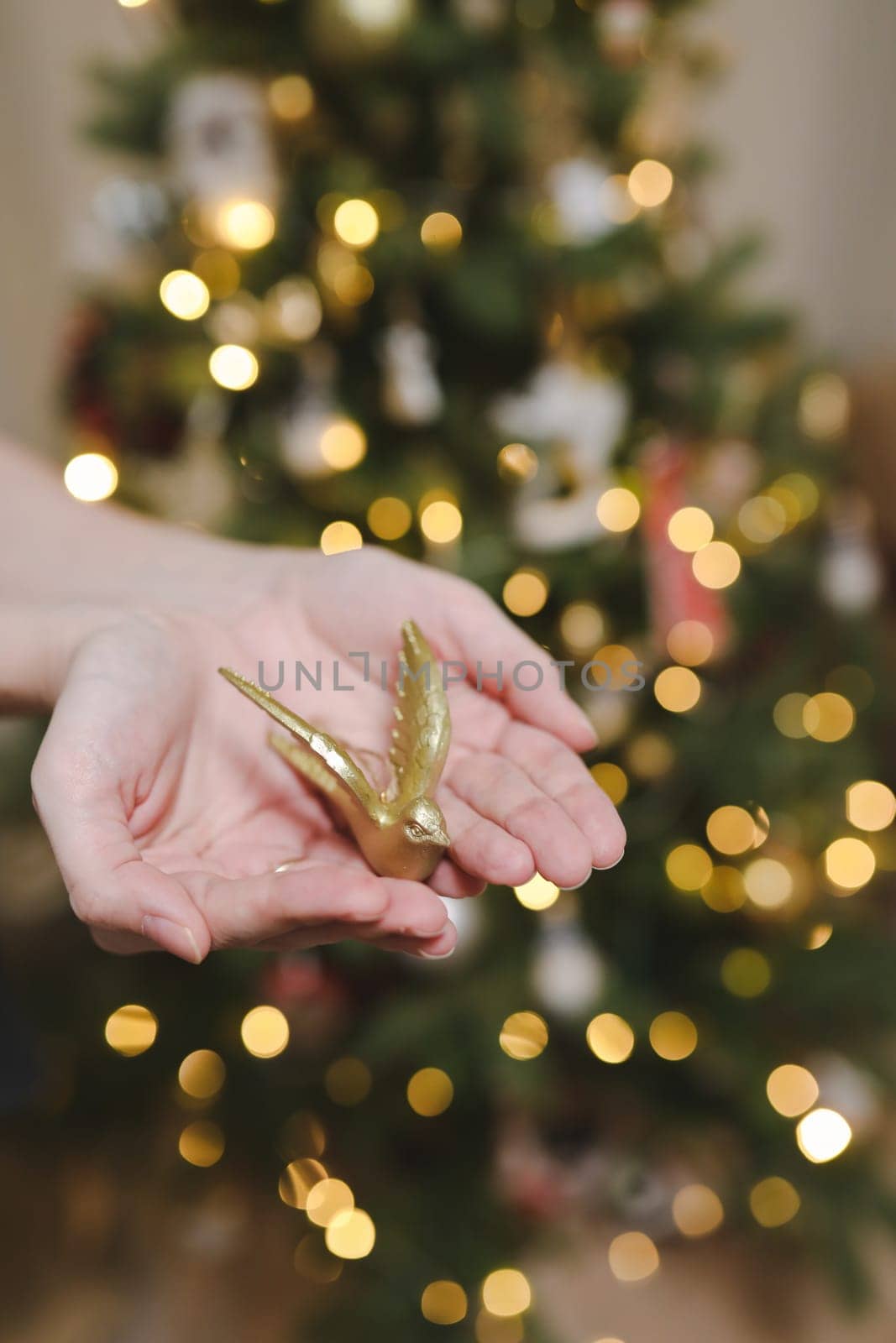 Decorating Christmas tree, holding Christmas toy in a hand. Holiday, Christmas and New Year family celebration concept.