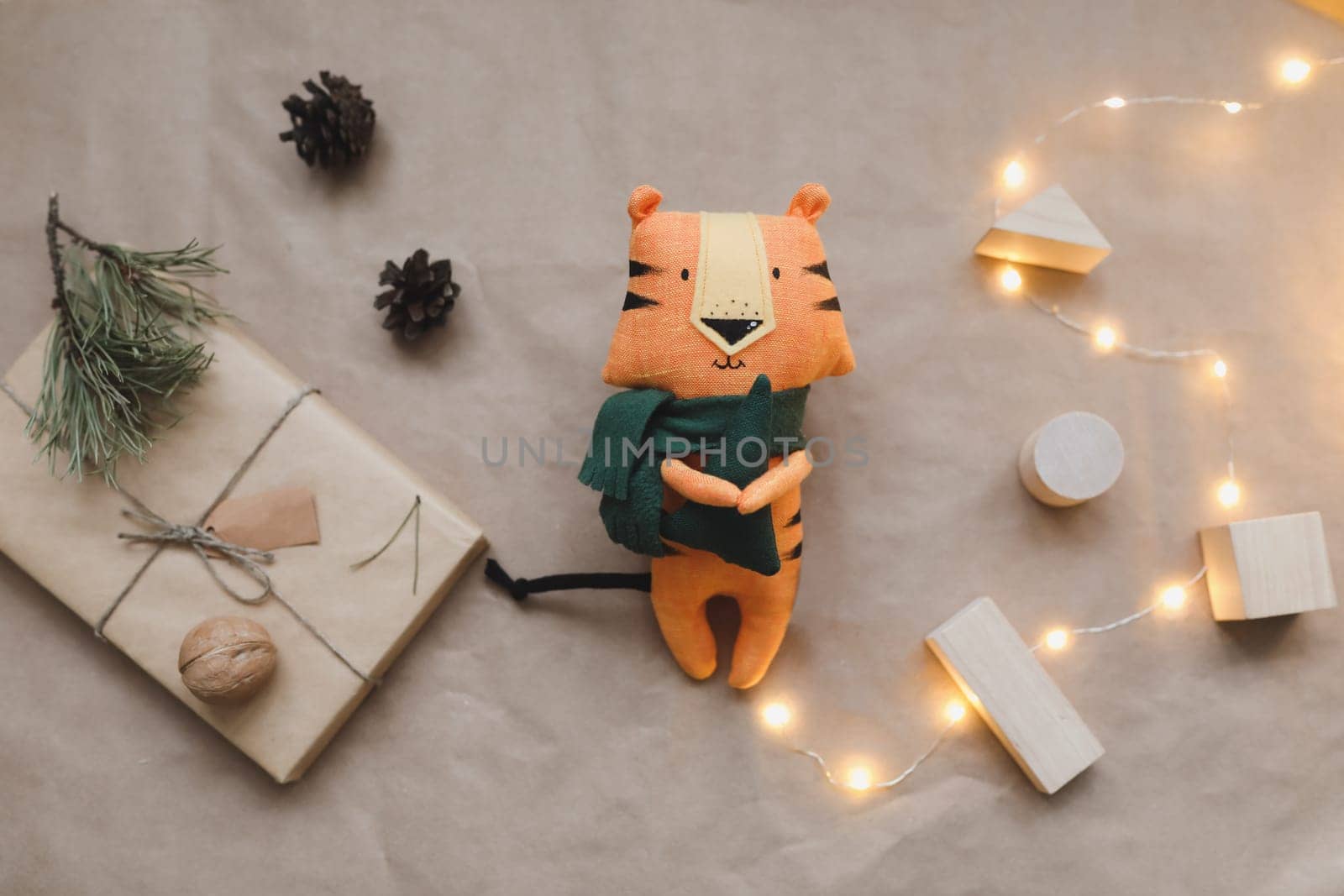 Christmas composition with a tiger toy, symbol of new 2022, a gift, fir tree branches and decorations. Christmas, winter, new year concept. Flat lay, top view by paralisart