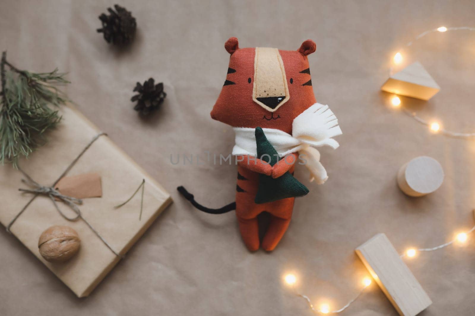 Christmas composition with a tiger toy, symbol of new 2022, a gift, fir tree branches and decorations. Christmas, winter, New year concept. Flat lay, top view.