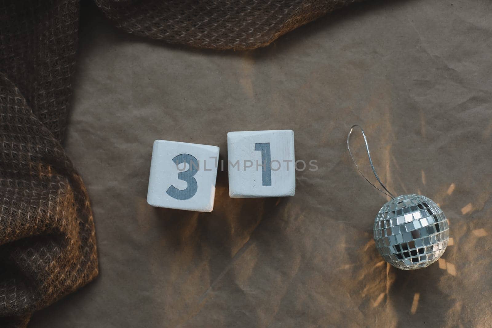 December 31 on white cubes calendar on a background with glowing garland